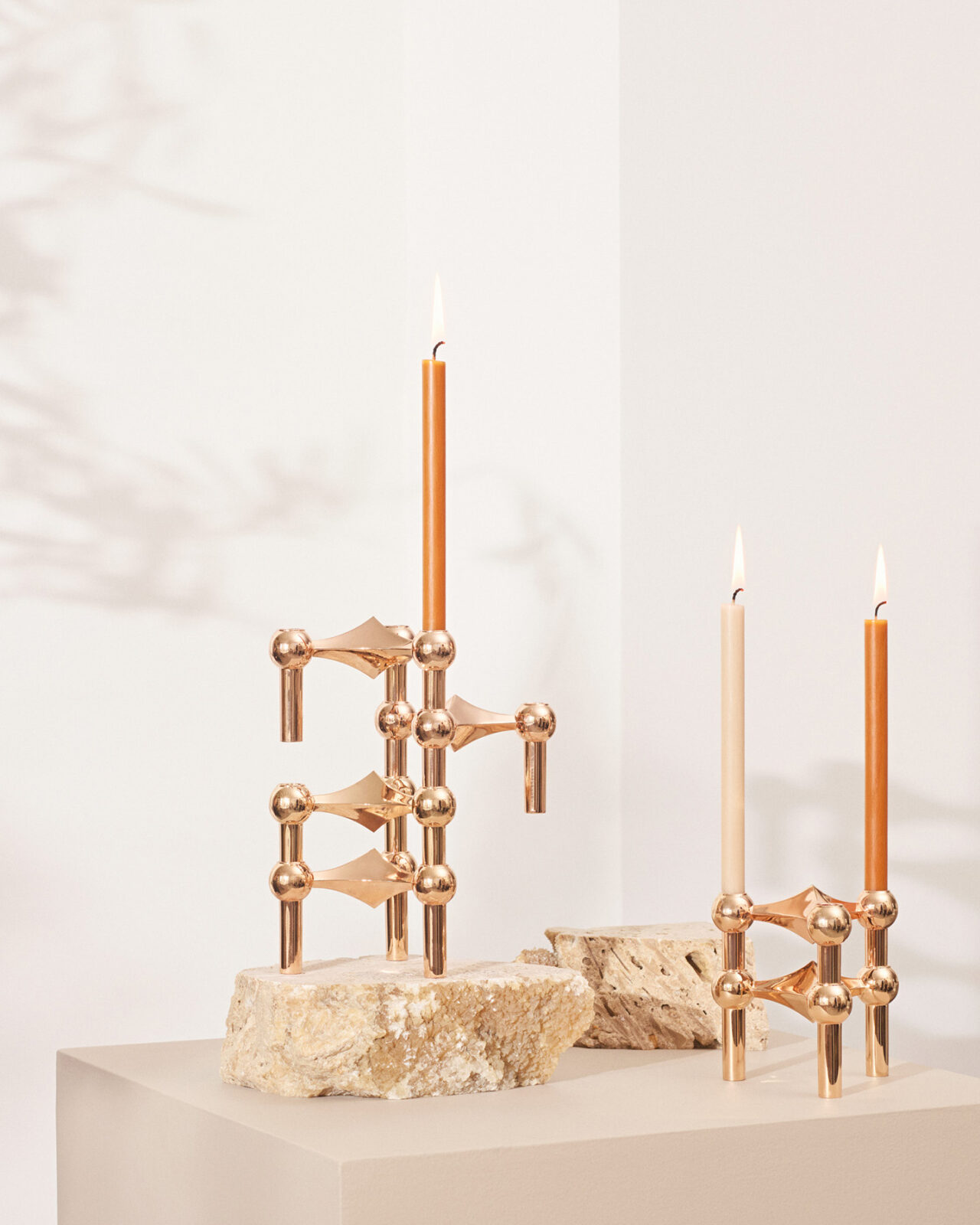 candles in camel and beige placed in rose gold candle holders