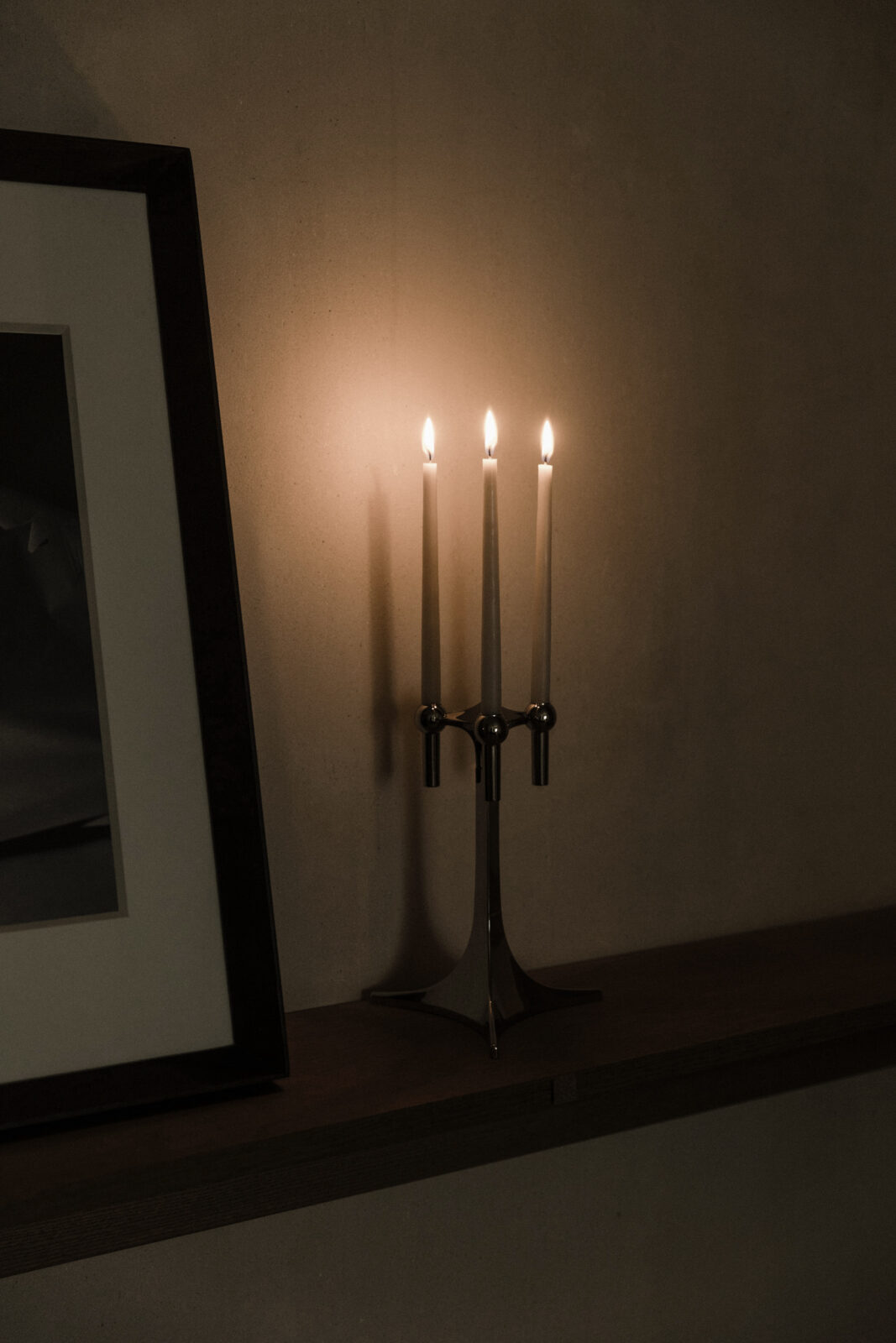 in the home of artistic duo Anton + Aiguabella decorating with a STOFF Nagel candelabra in chrome with lit taper candles.