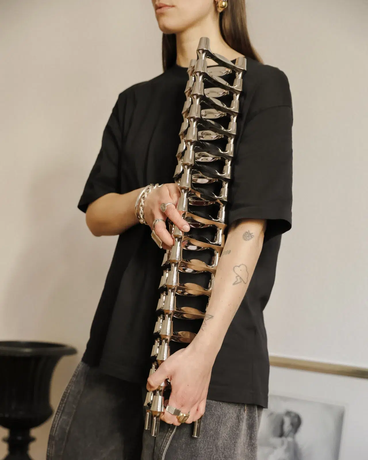 Linda Käckermann for STOFF Nagel holding a stack of BMF candle holders in chrome.