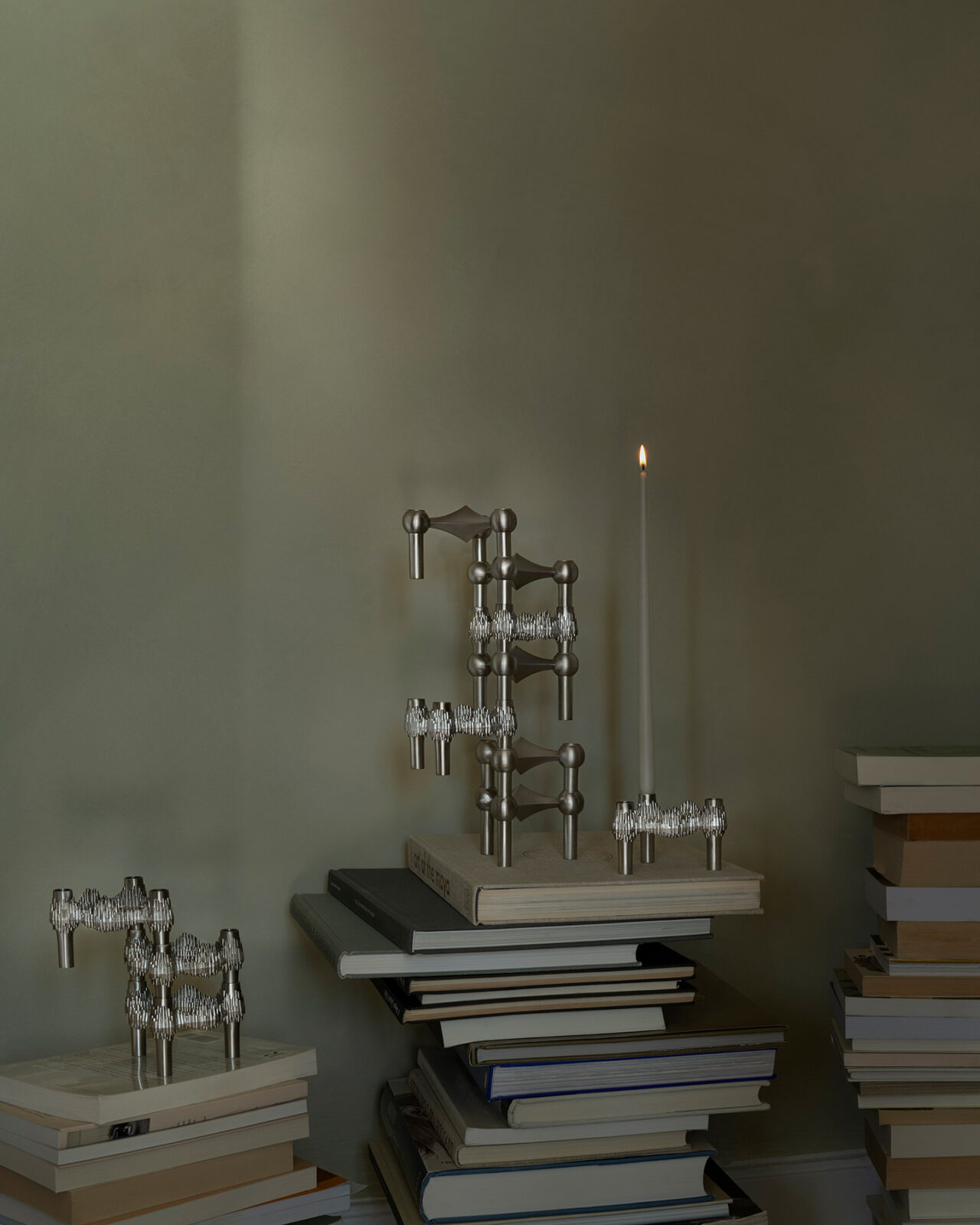 Quist candle holder combined with Nagel candle holder in brushed chrome styled on books in sculptural arrangements.