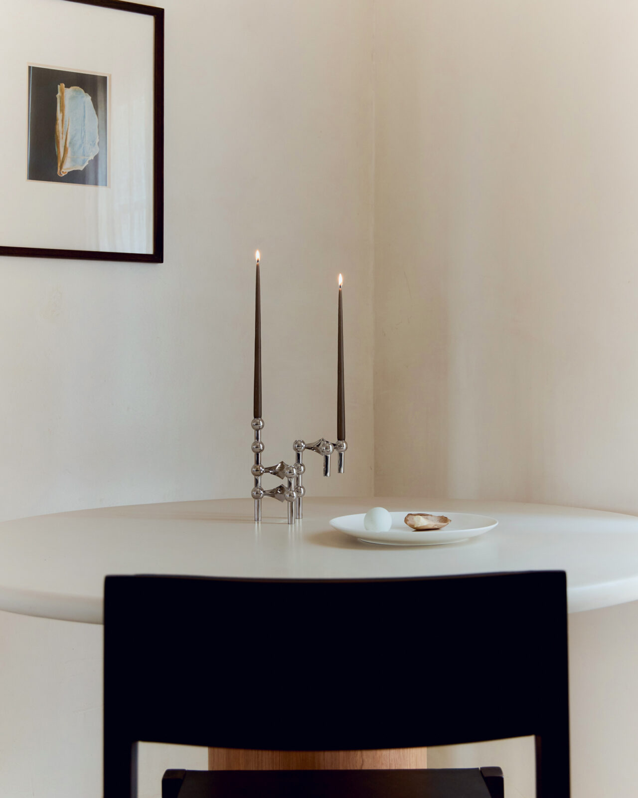 stoff nagel x claudia longarte. nagel candle holders in chrome arranged on a table with two lit candles