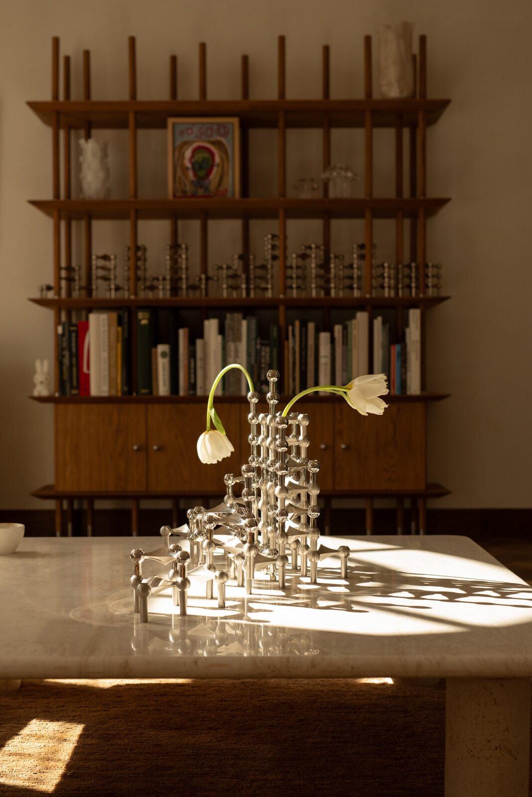 a summer styling by bonnie barlag for stoff nagel featuring a large candle holder sculpture of the nagel candle holder in brushed chrome and shiany chrome