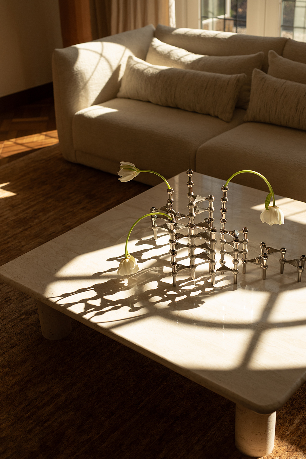 a summer styling by bonnie barlag for stoff nagel featuring a large candle holder sculpture of the nagel candle holder in brushed chrome and shiany chrome